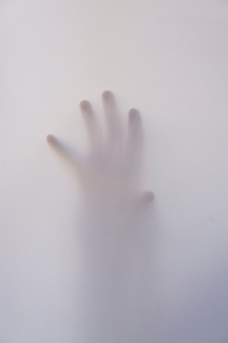 Hand behind frosted glass